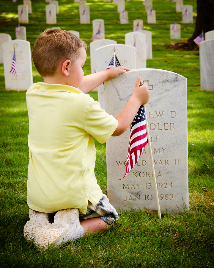 young boy visiting grave on memorial day